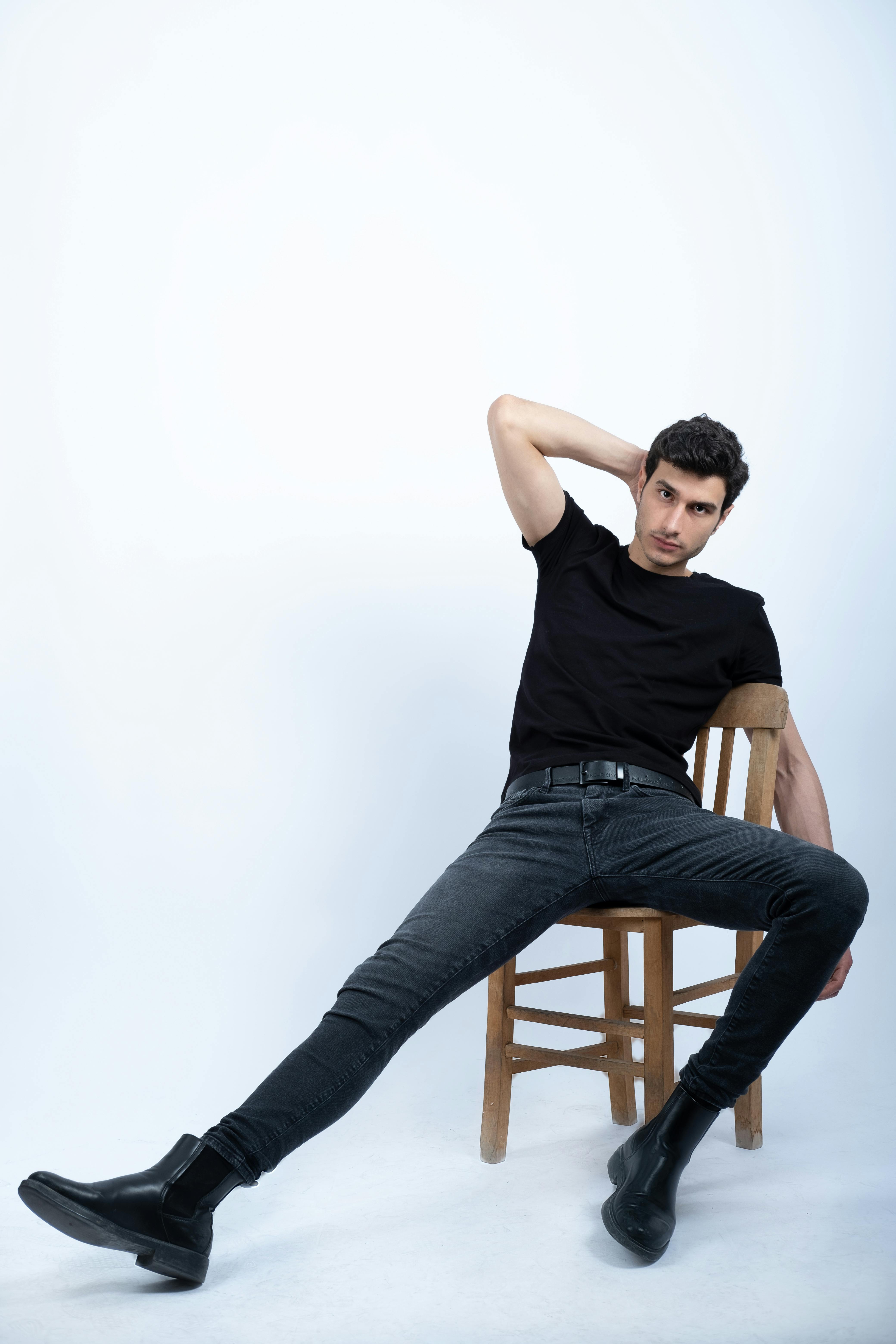 free photo of young man in a black outfit posing in studio