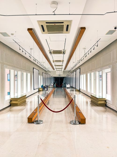 Free Empty modern interior hallway with a polished floor and a red rope barrier, offering ample copy space. Stock Photo