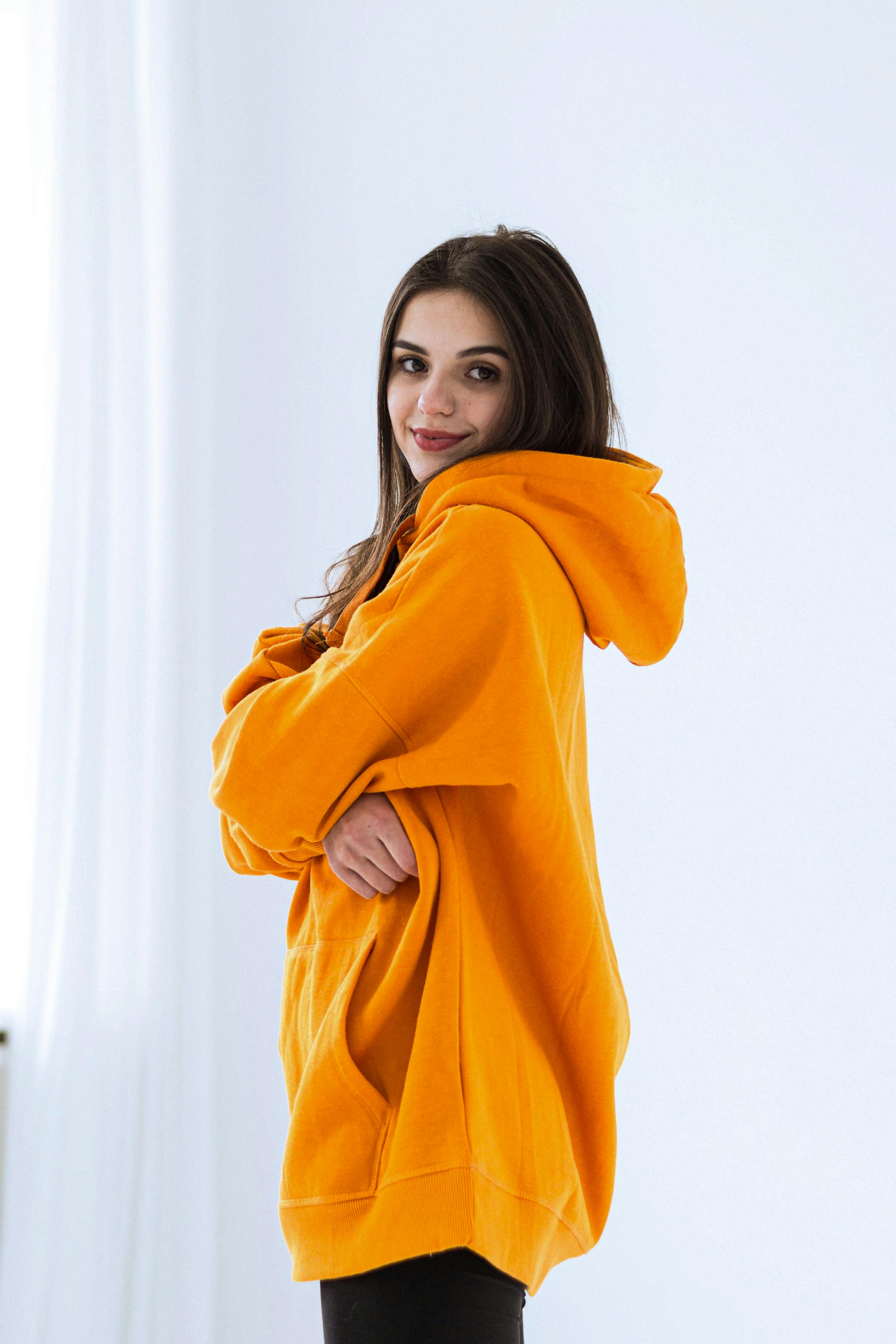 Woman Posing in Yellow Hoodie · Free Stock Photo