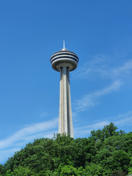 Vertical shot of Skylon Tower in Niagara Falls, Ontario, against a clear blue sky.