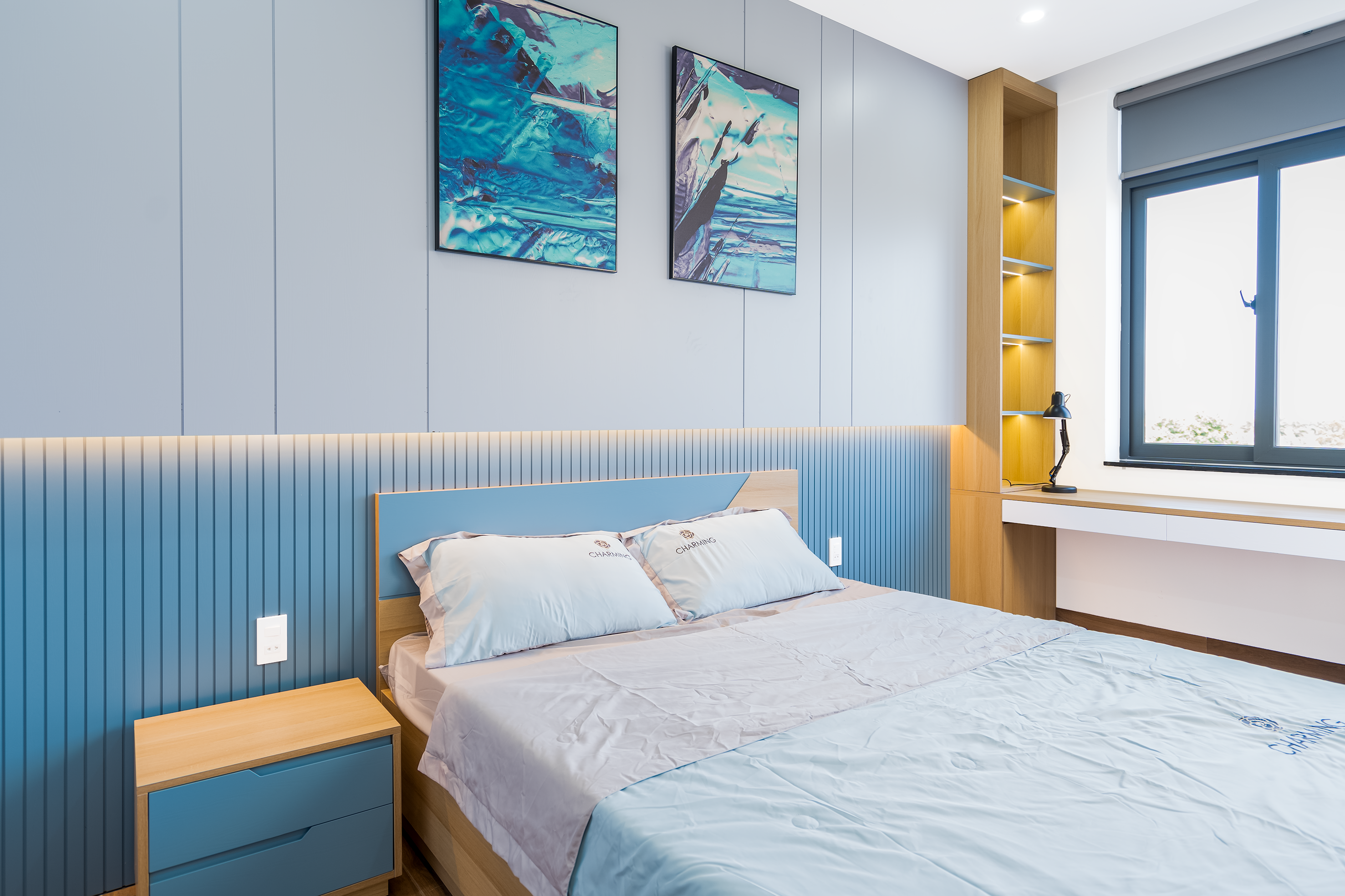 Elegant minimalist bedroom with blue accents and contemporary decor.