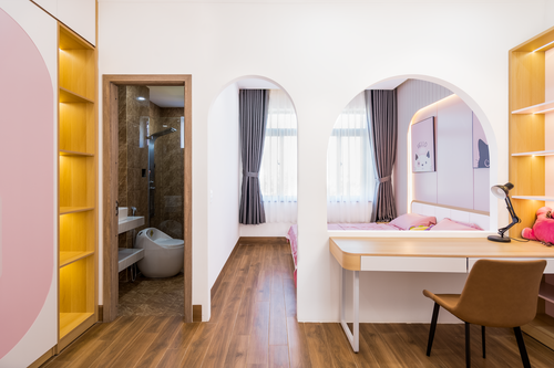 Free Stylish bedroom with pink and white decor featuring an elegant bathroom and desk area. Stock Photo