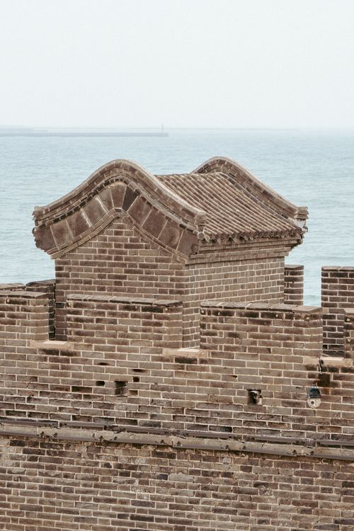 Free Red brick fort tower with unique roof design by the seaside, showcasing historical architecture. Stock Photo