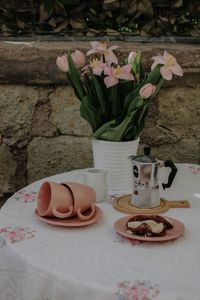 Outdoor breakfast table with tulips and stovetop pot — photo by Nati on Pexels