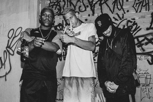 Black and White Photo of Three Young Man in Baggy Clothing