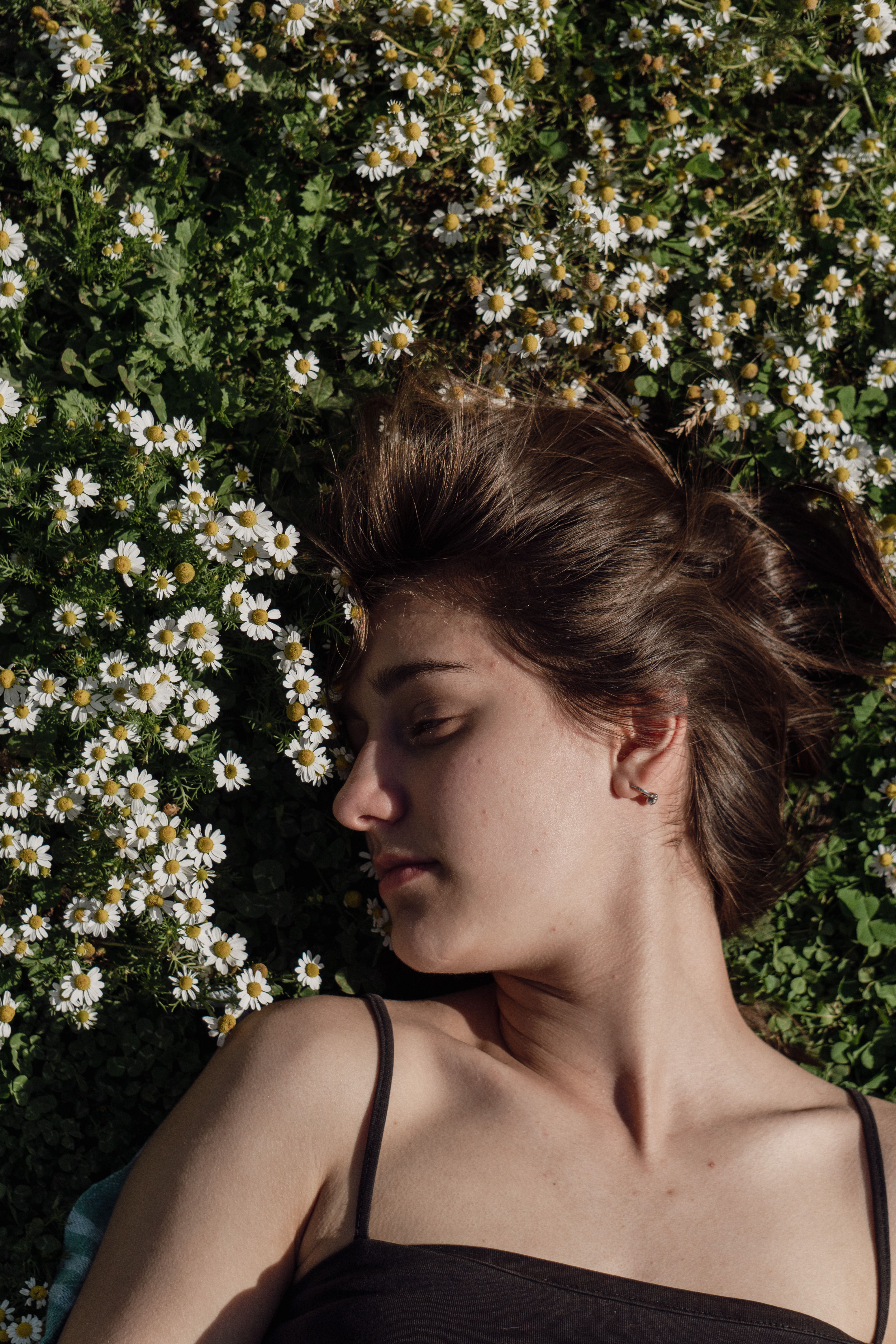 Young Woman Lying on a Meadow with Daisies in Sunlight with Eyes Closed ...