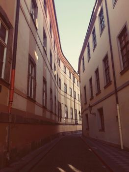 Explore a serene narrow alley amidst historic buildings in Prague's Old Town, perfect for travel enthusiasts.
