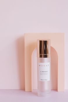 Monat serum vial on minimalist pink background, highlighting luxurious packaging.