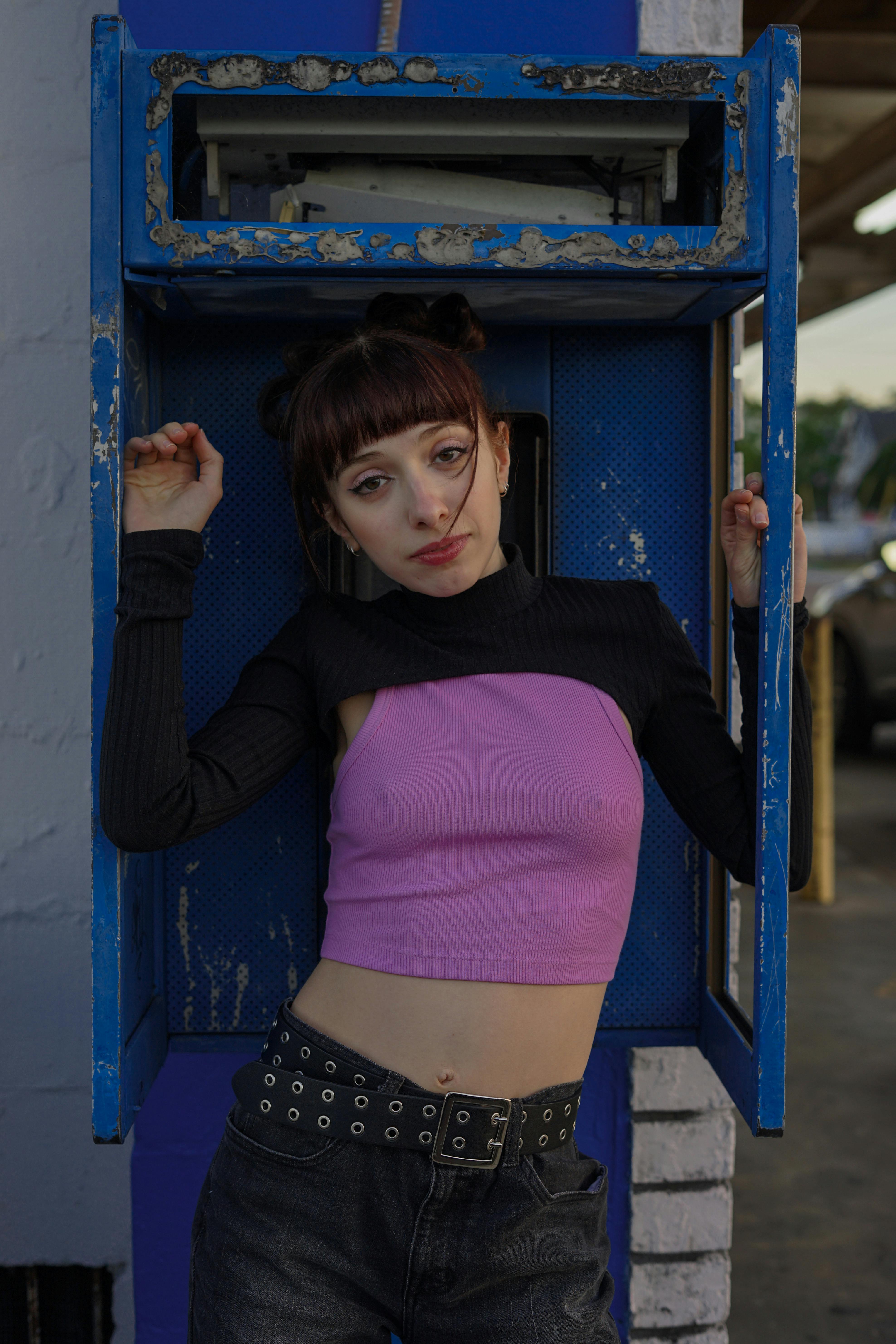 Stylish young woman in Y2K fashion poses in an urban setting, showcasing modern trends.