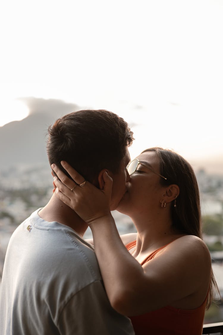 A Couple Kissing In Front Of A City View