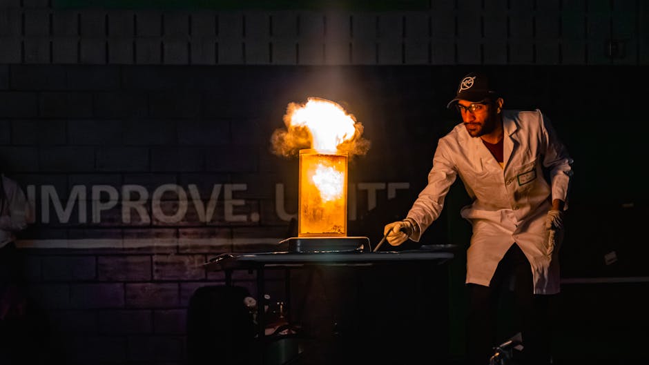 A scientist in a lab coat demonstrates a dramatic fire explosion experiment indoors.