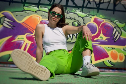 Woman Sitting and Posing by Wall with Graffiti