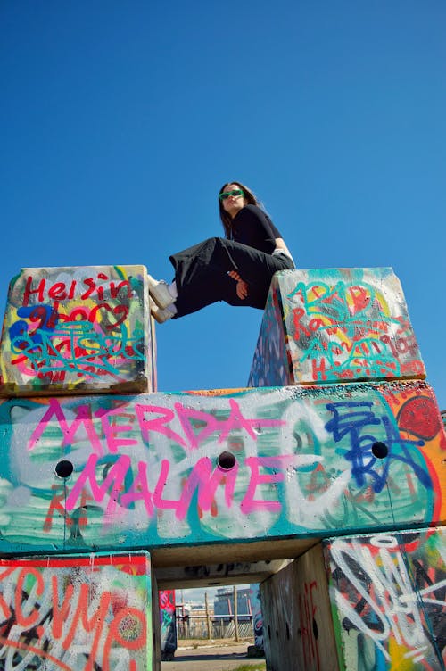 Woman Sitting on Walls with Graffiti