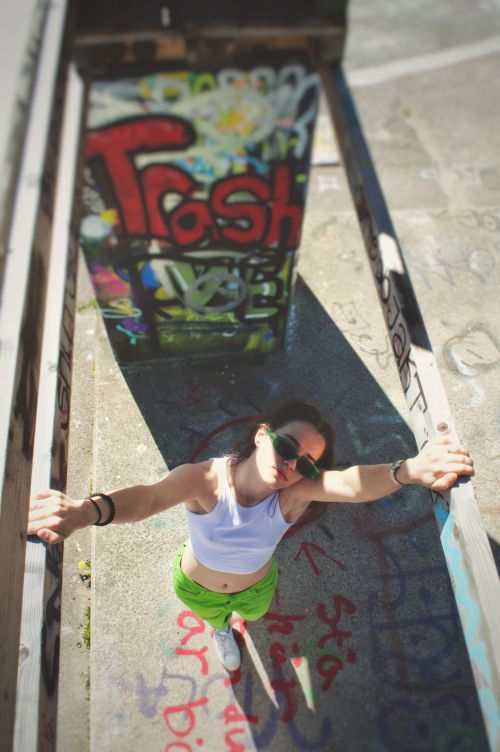 Free High angle view of a woman in a crop top and green pants in an urban graffiti setting. Stock Photo