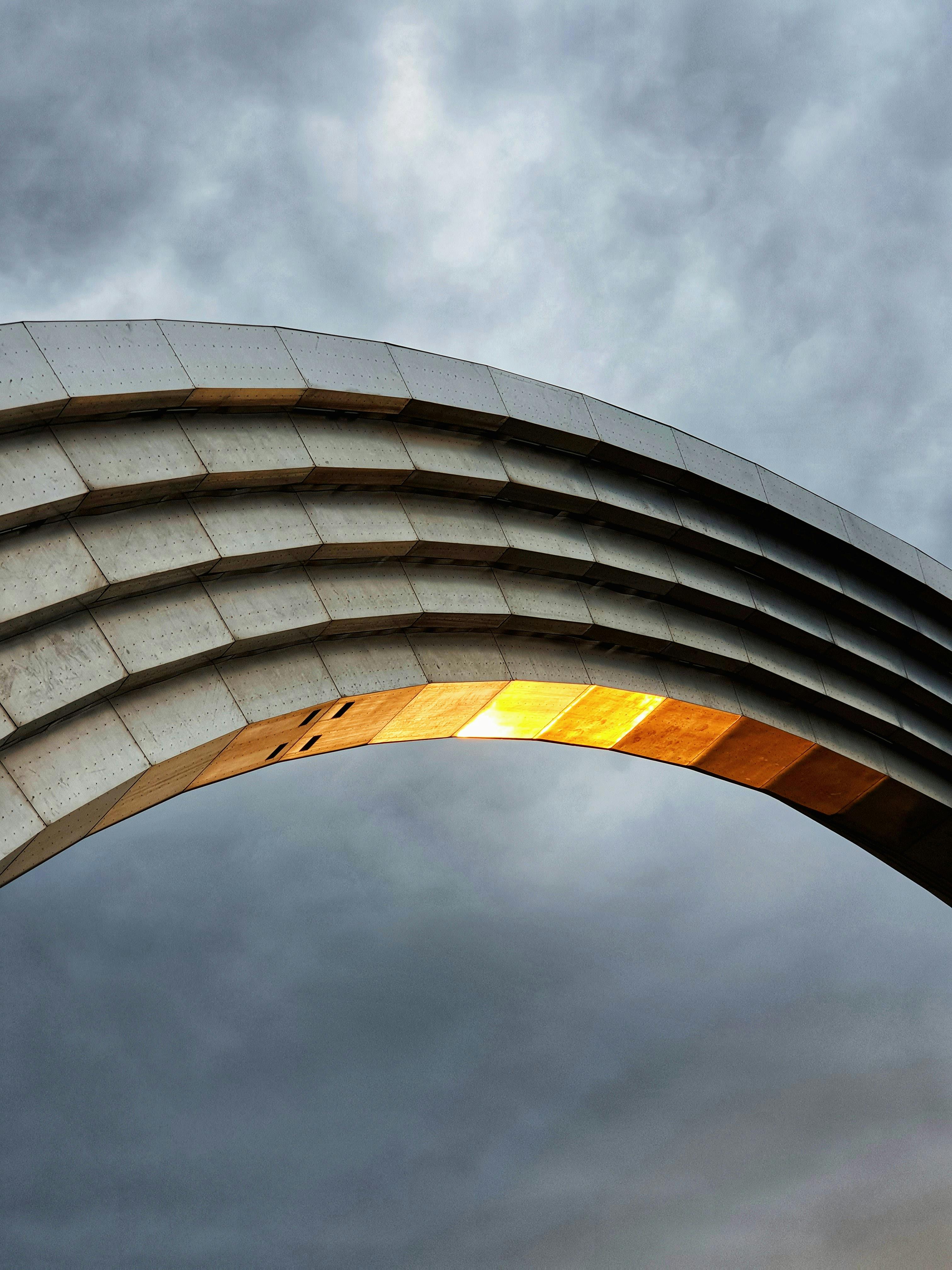 A stunning metallic arch set against a dramatic sky, capturing Kyiv's modern architecture.