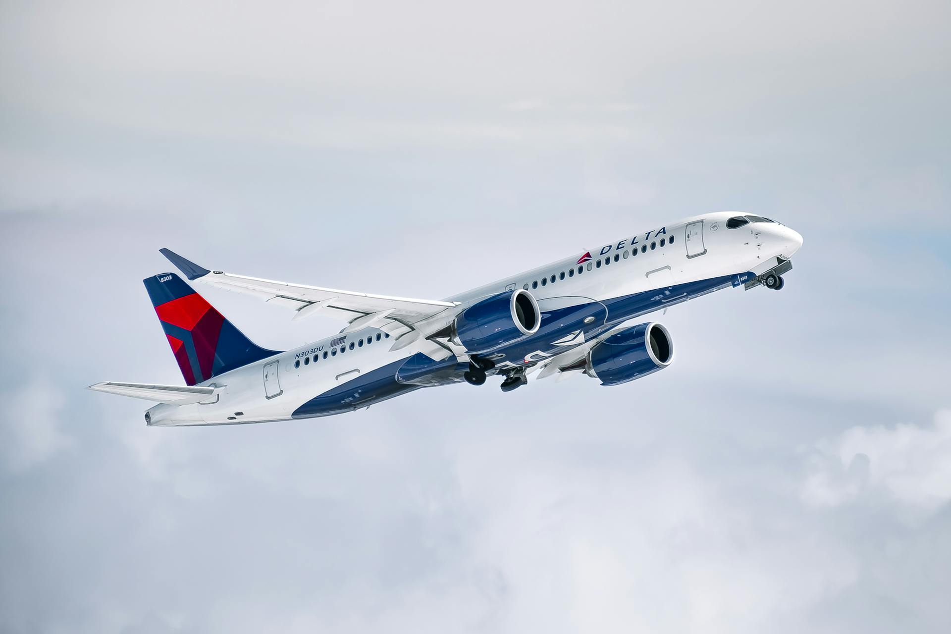 A Delta Air Lines aircraft flying high above clouds, showcasing modern aviation technology.