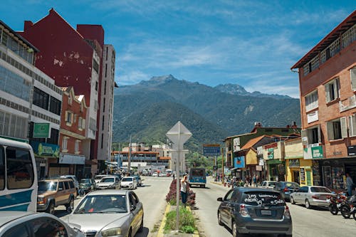 View of a Street with Parked Cars and Residential Buildings in a City with View of Mountains 