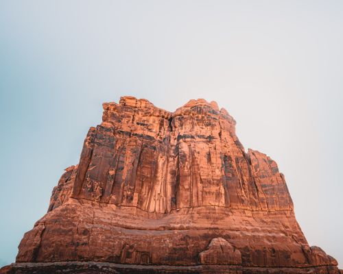 Free Golden sandstone cliffs stand tall under a clear blue sky in Arches National Park, Utah. Stock Photo