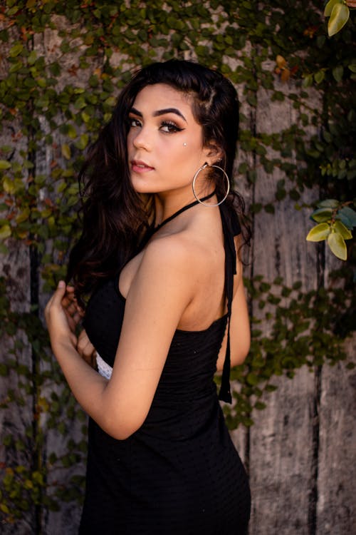 A Young Brunette Standing Against the Wall