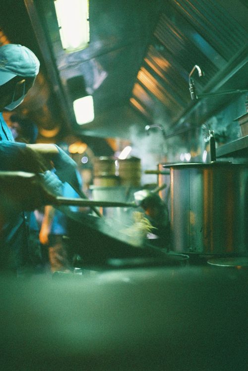 Free A chef skillfully stirring noodles in a lively restaurant kitchen, captured in Lisbon. Stock Photo