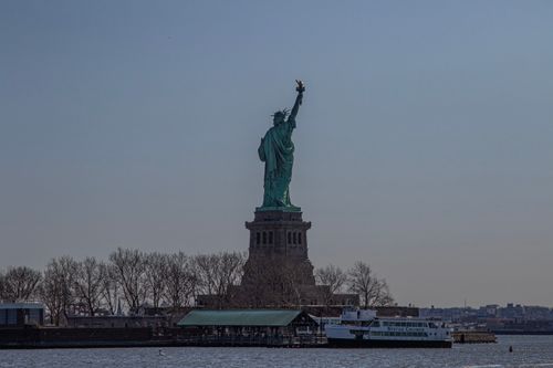 Free View of the iconic Statue of Liberty from Jersey City waterfront, showcasing its majestic presence. Stock Photo
