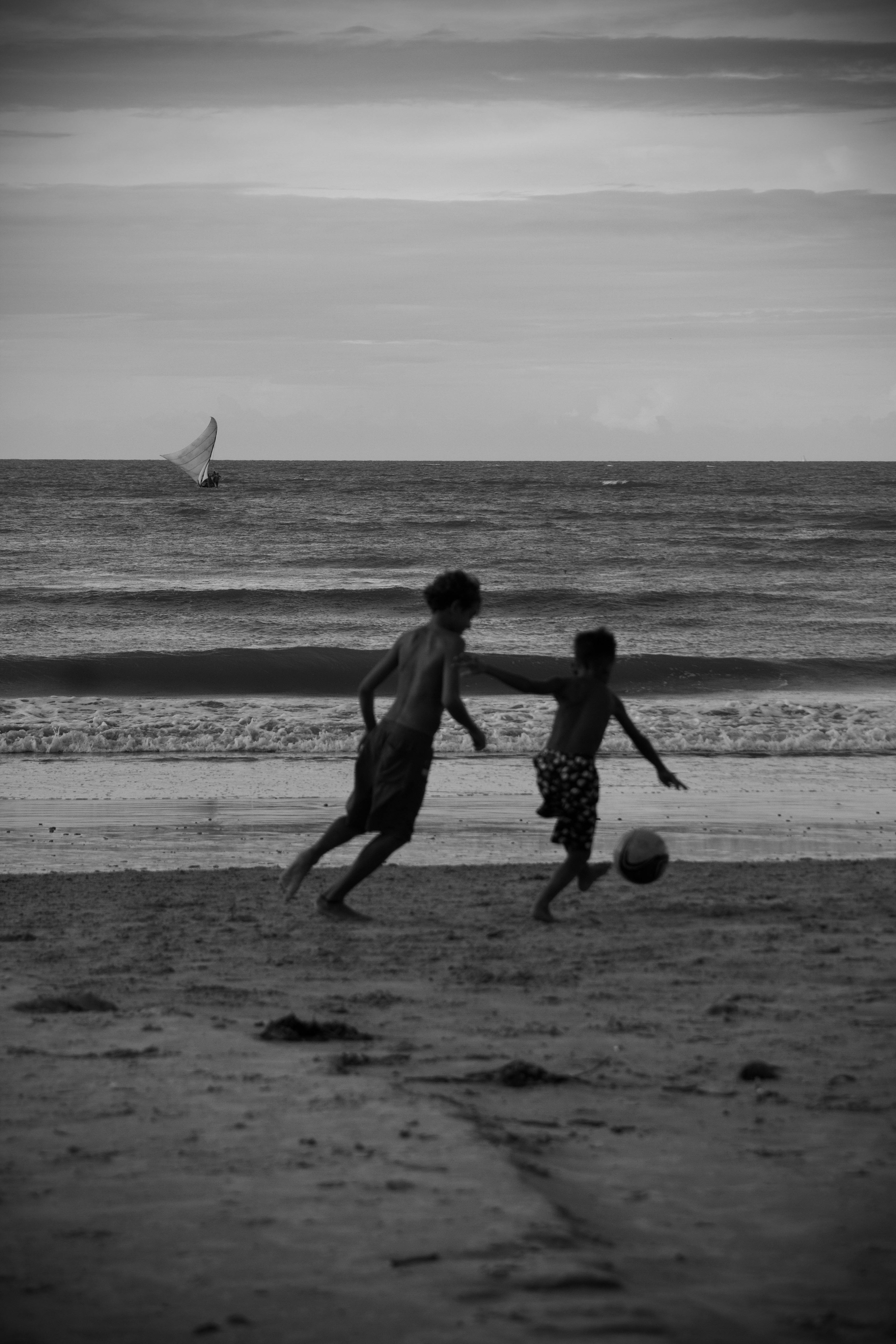 children playing football on beach