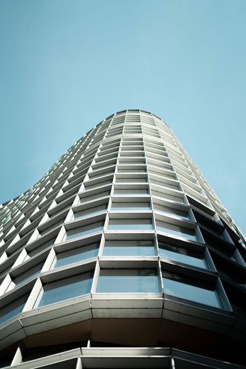 Free Low-angle view of a modern skyscraper with a sleek design and clear sky background. Stock Photo