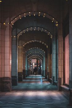 Stylish arched corridor in Calgary adorned with lights, creating a moody nighttime ambiance.