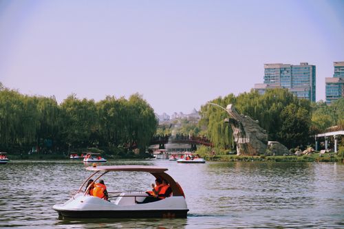 Free Enjoying a pedal boat ride on a peaceful pond surrounded by lush greenery in Xi'An, China. Stock Photo