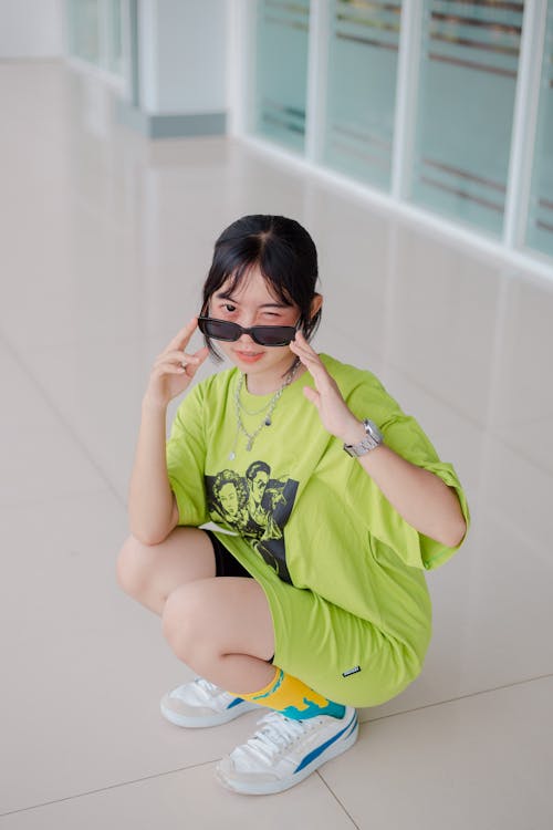 녹색 티셔츠, 무릎 꿇고 있는, 선글라스의 무료 스톡 사진