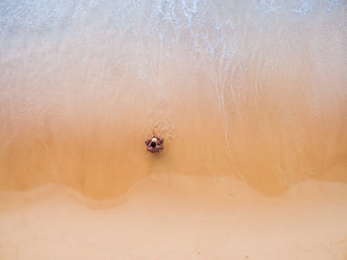 男子坐在海灘上的航拍
