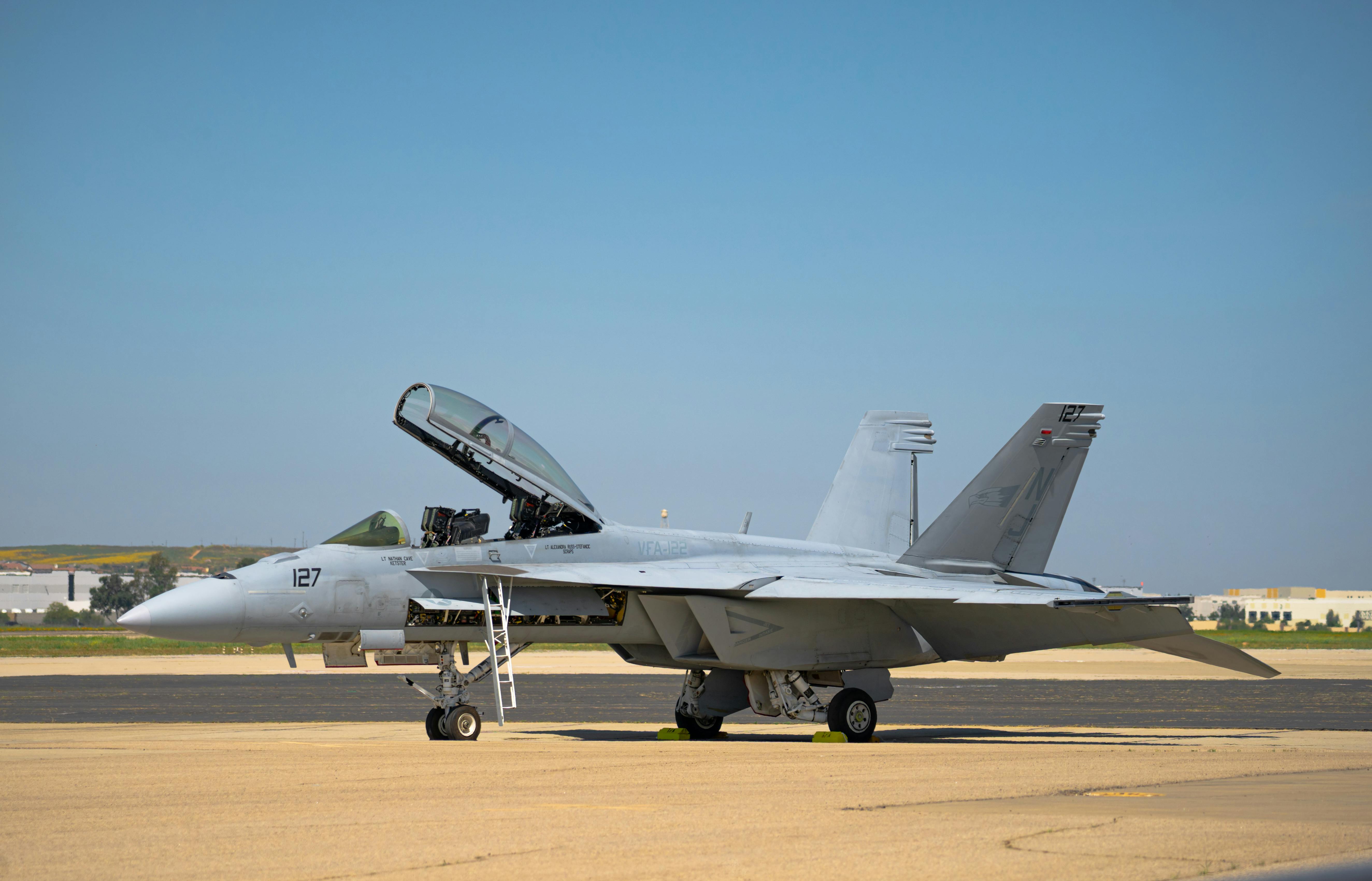 Military F/A-18 Super Hornet aircraft stationed on a tarmac at March Air Reserve Base under clear skies.