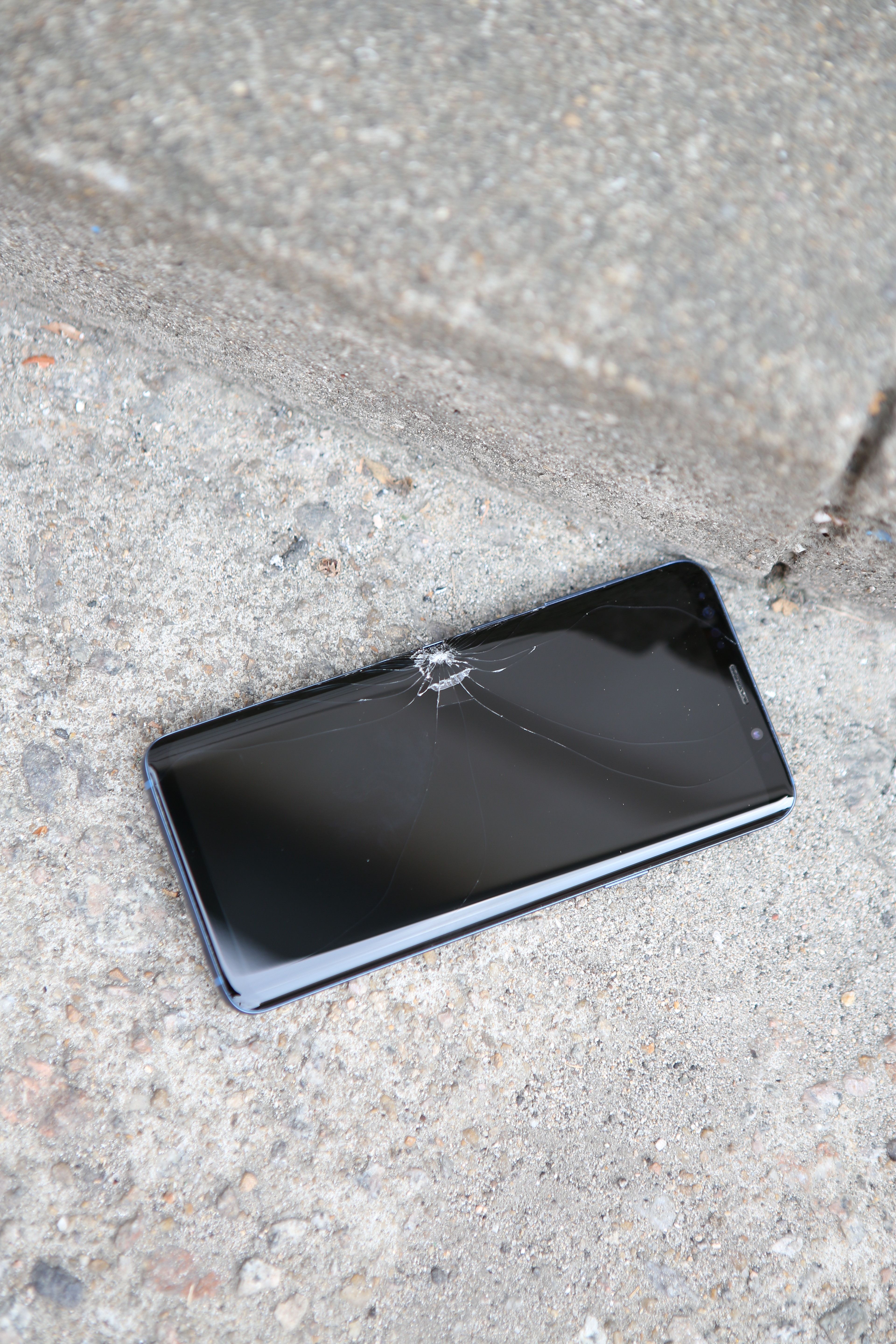 Broken phone on concrete