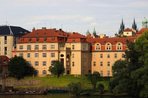 Free Scenic view of historic buildings with red roofs and lush greenery in a European city. Stock Photo