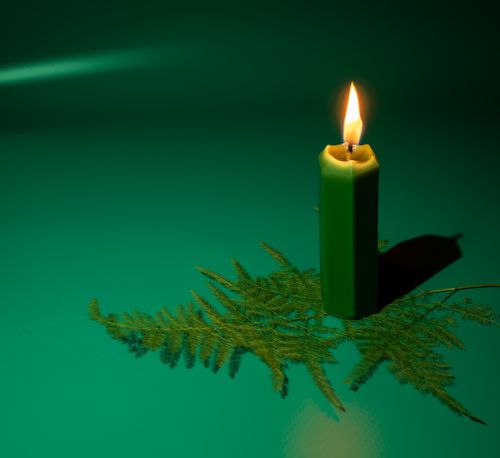 Free Burning candle on the green background Stock Photo