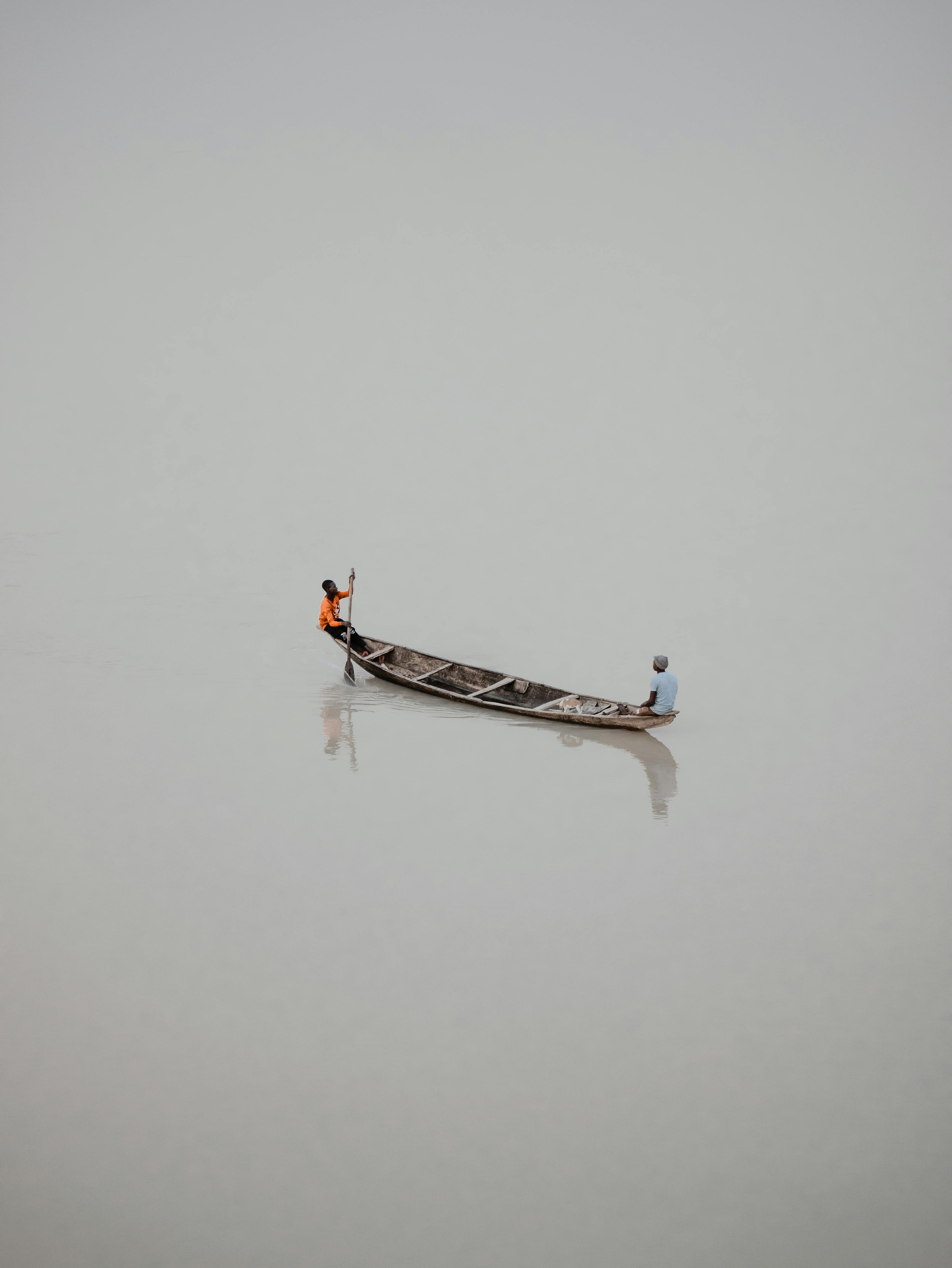 Two fishermen in a canoe, serene scene from Jebba, Nigeria, captured from above.