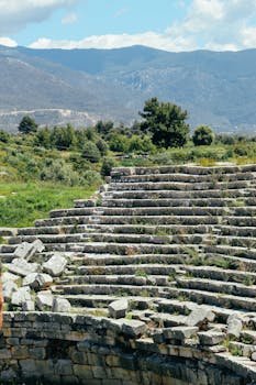 Explore the ancient amphitheater ruins of Ksantos in Antalya, Türkiye, surrounded by stunning mountains.