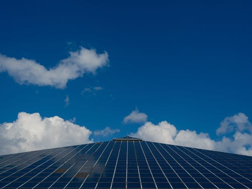 Triangular Solar Panels with Blue Sky and Clouds above 