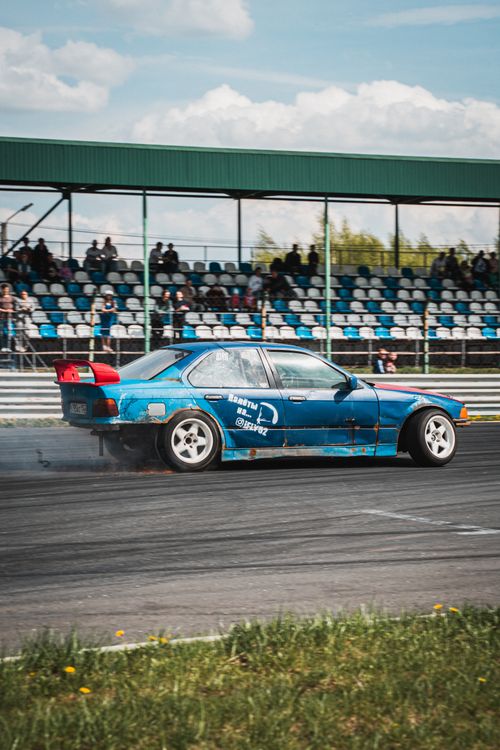 Free Blue drift car racing with speed and precision on a competitive race track. Stock Photo