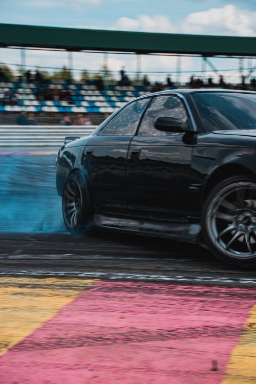 Free Close-up of a car drifting on a colorful track during a motorsport event. Stock Photo