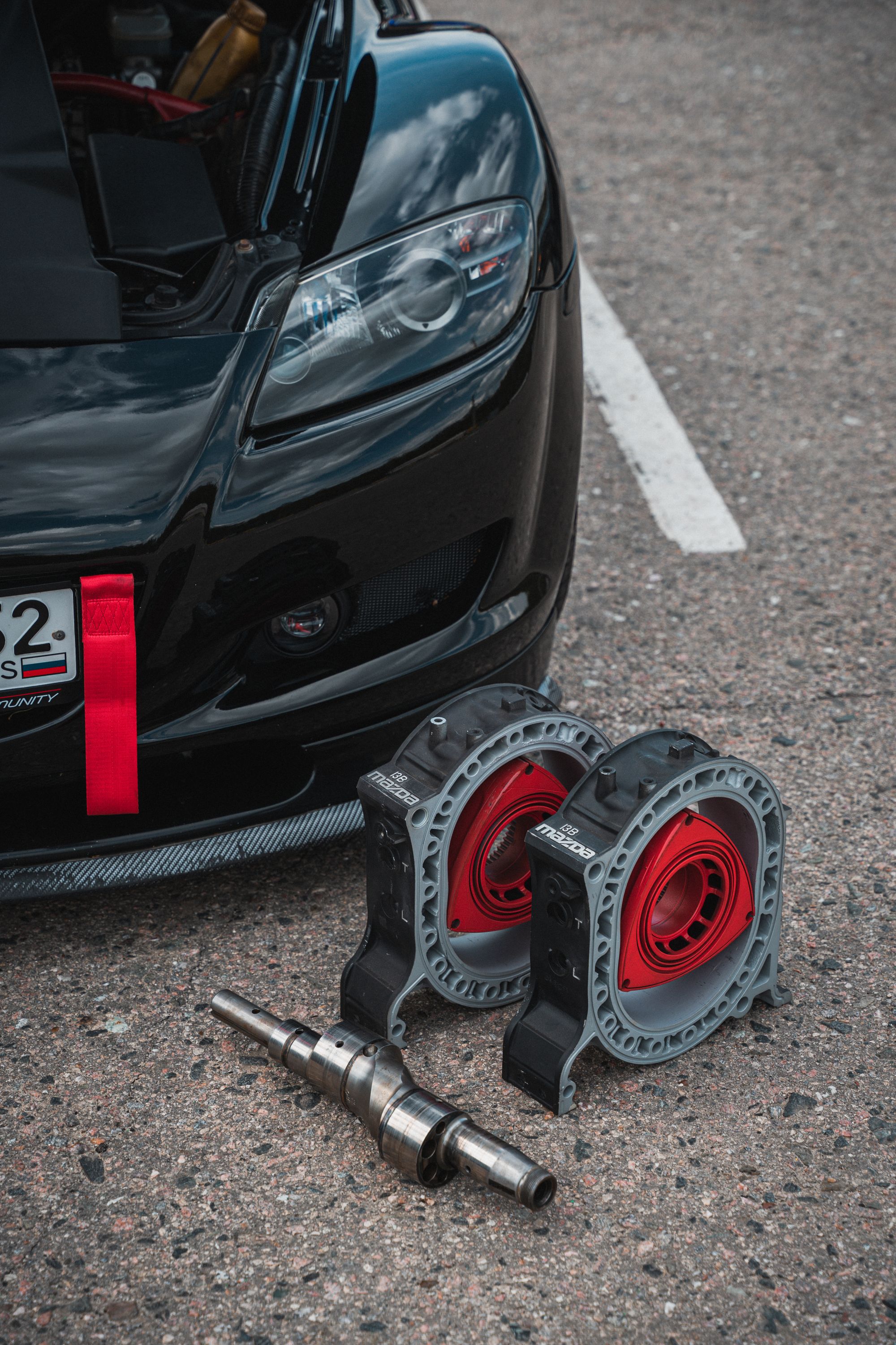 Shows rotary engine housings and eccentric shaft laid out beside what appears to be a Mazda RX-8, directly relevant to&hellip;