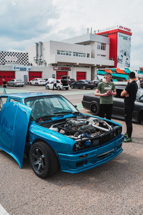 Free Sports car with open engine hood at outdoor auto show. Enthusiasts discuss cars. Stock Photo