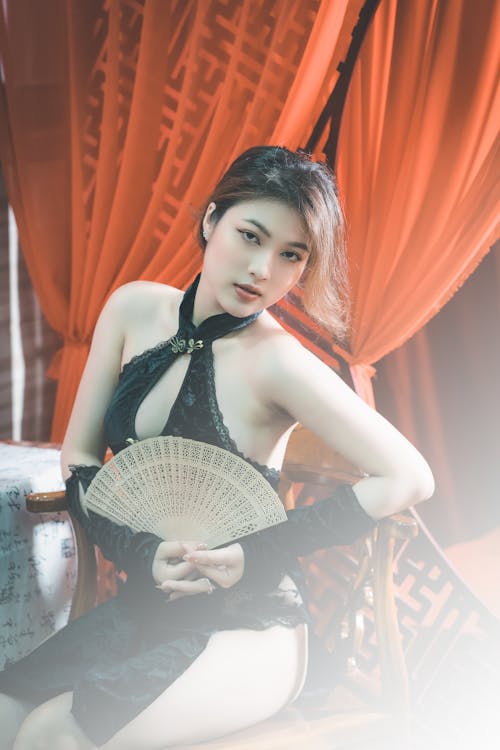 Young Woman in Black Lingerie Holding a Fabric Fan 