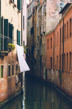 Charming Venice canal scene with historic architecture and hanging laundry.