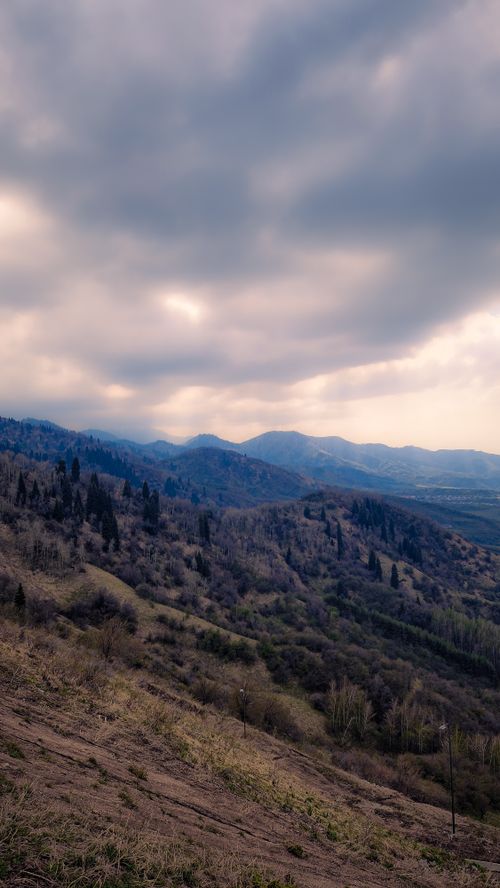 Free Explore a serene mountain view with overcast skies capturing the tranquil essence of nature's raw beauty. Stock Photo