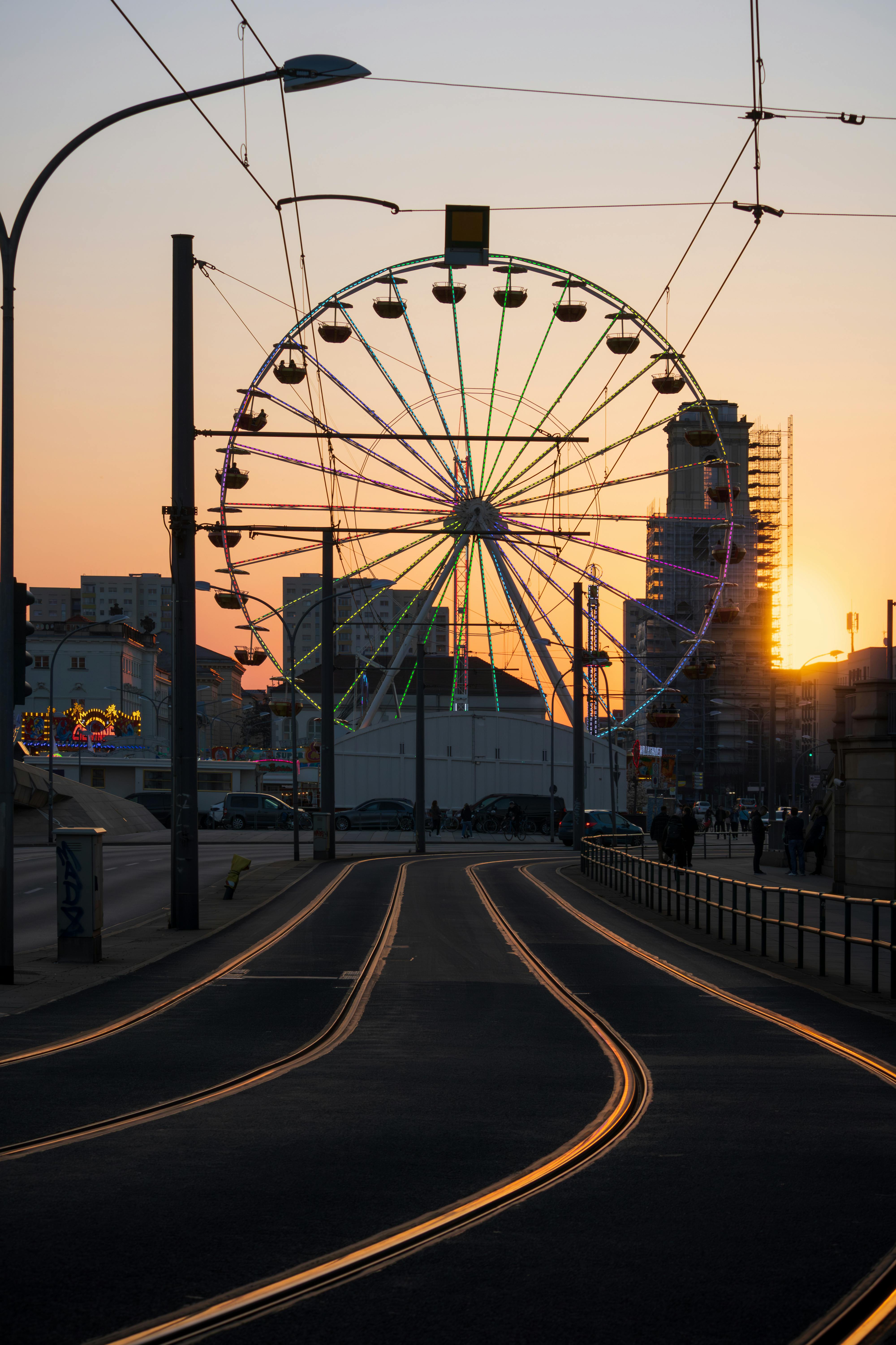 a ferris wheel at sunset on a street