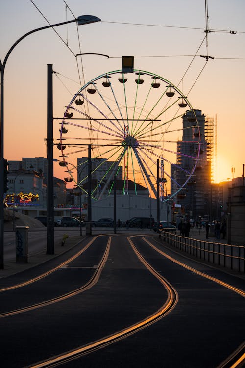 A ferris wheel at sunset on a street