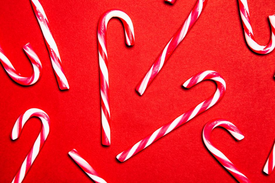 Festive candy canes on a red background, perfect for Christmas themes.