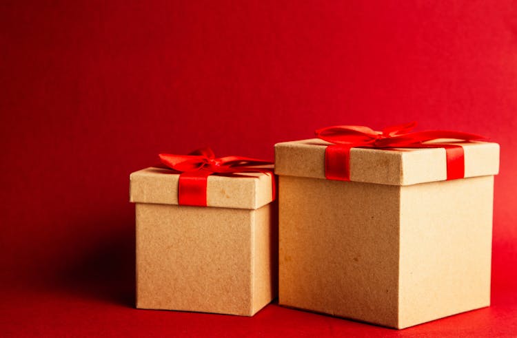 Two Brown-and-red Gift Boxes On Red Surface