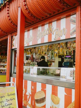 A vibrant snack bar with red and white striped decor, offering a variety of snacks and drinks.